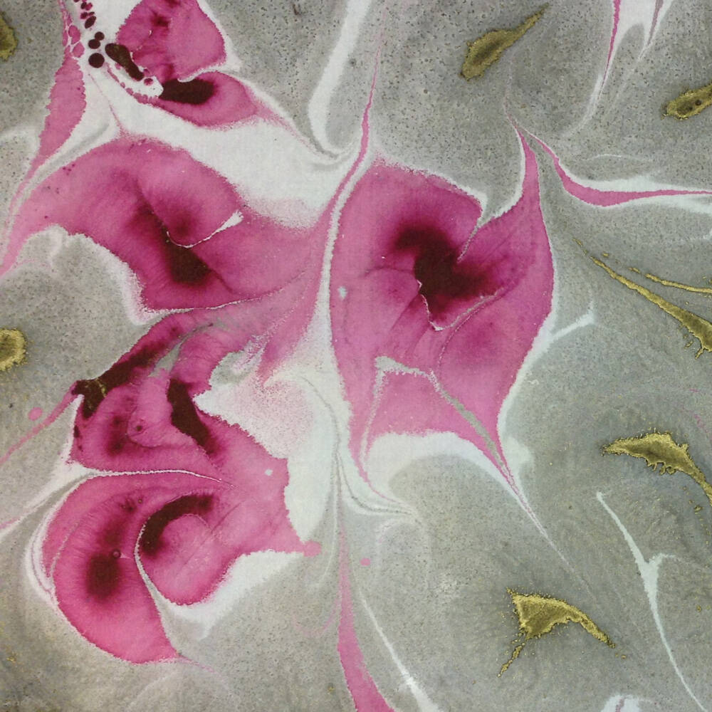 Marmorpapier/marbled Paper in den Farben pink, grau und gold. Es zeigt ein Fantasiemuster bei dem das Pink überwiegt.
